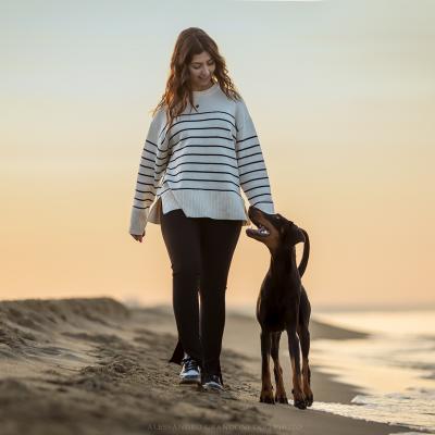 Cane Dobermann E Padrone camminano all'Alba al Mare